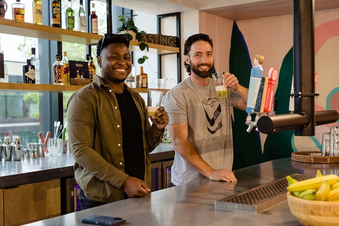 A dark skinned man and a light skinned man smiling at our Austin campus.