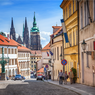 A cobbled road in Prague with picturesque old building down either side.