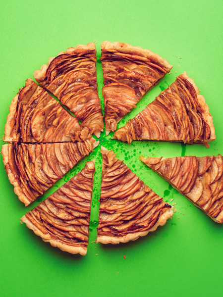 A baked pie with 8 pieces against a green background