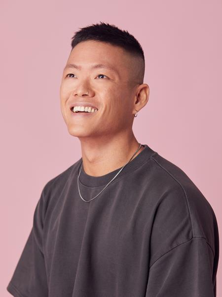 Man sitting on a stool smiling off at the distance