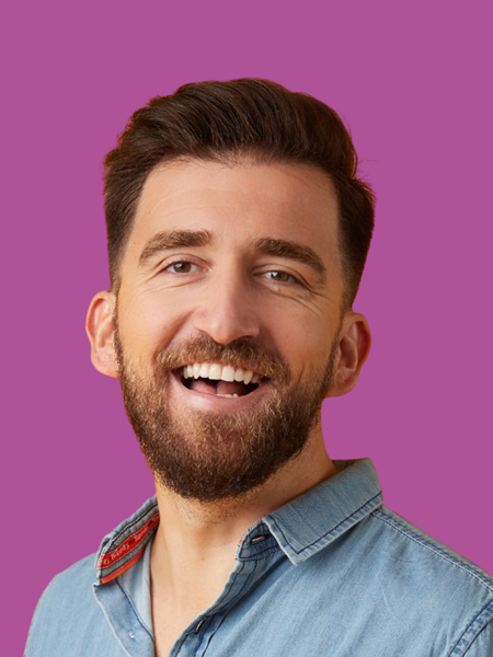 Light skinned man in blue denim shirt, smiling.