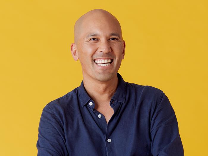 Man wearing a blue shirt with arms folded smiling to the camera