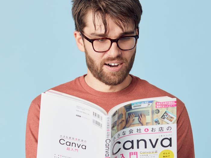 Man reading a book and sitting on a stool