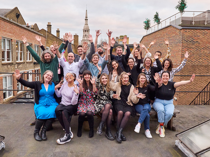 The Canva UK team waving their hands in the air