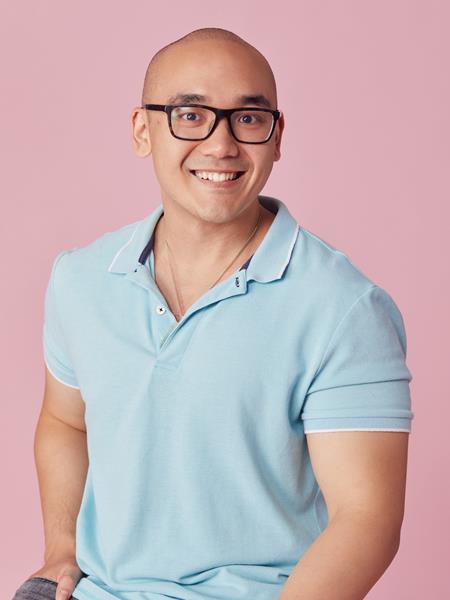 Medium skinned man with black framed glasses, blue polo shirt and jeans.