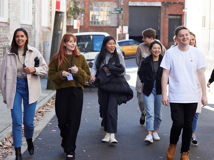 Group of people walking down a laneway towards the camera looking off into the distant
