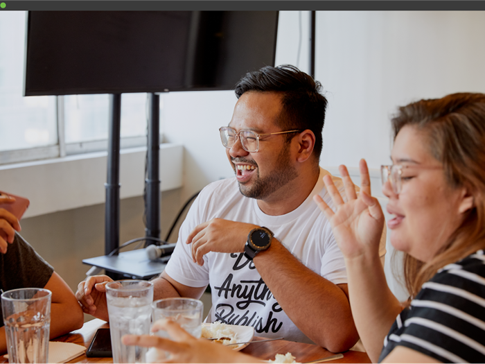 2 people sitting at a desk laughing