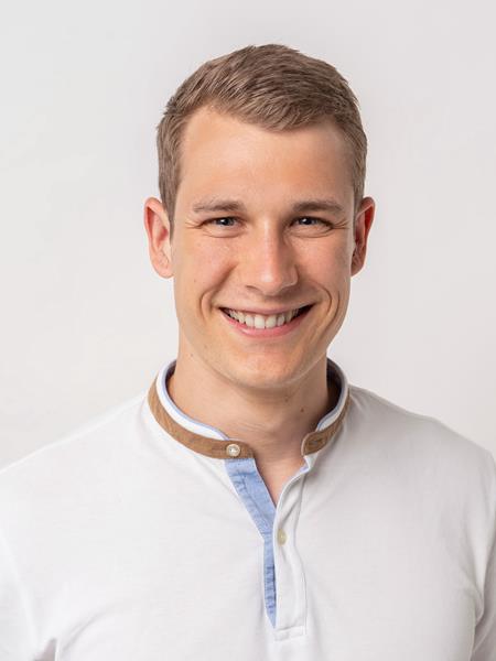 Man with blonde hair smiling to the camera