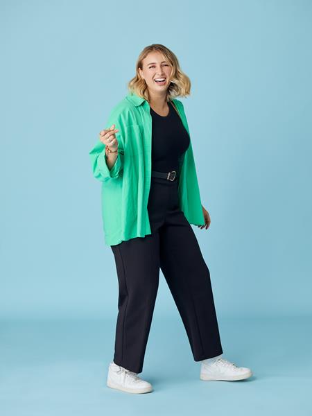 Woman in green shirt clicking with her fingers and smiling
