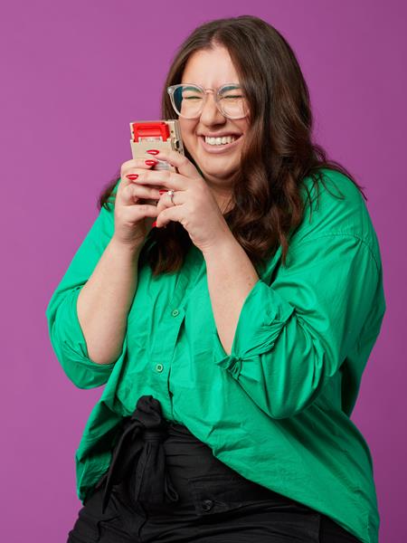 Women in green top holding a gameboy and laughing