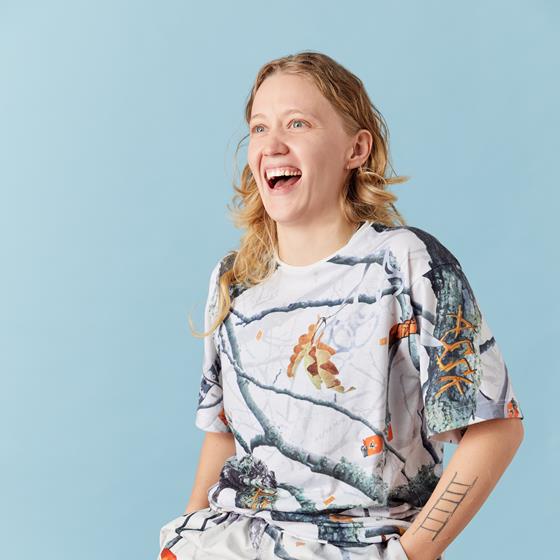 Woman sitting on a chair laughing and smiling into the distance