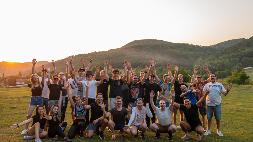 Group of people posing for a photo with their hands in the air