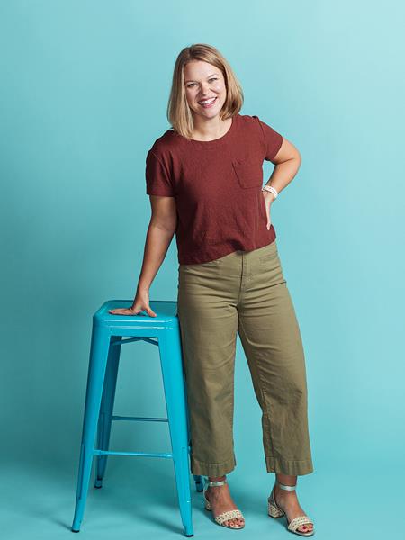 Women in a red shirt posing next to a stool