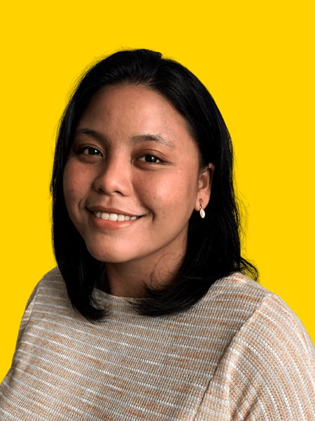 Medium skinned woman in a beige top, smiling.