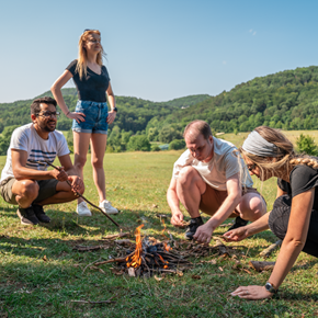 Group of people outside in a park making a fire together