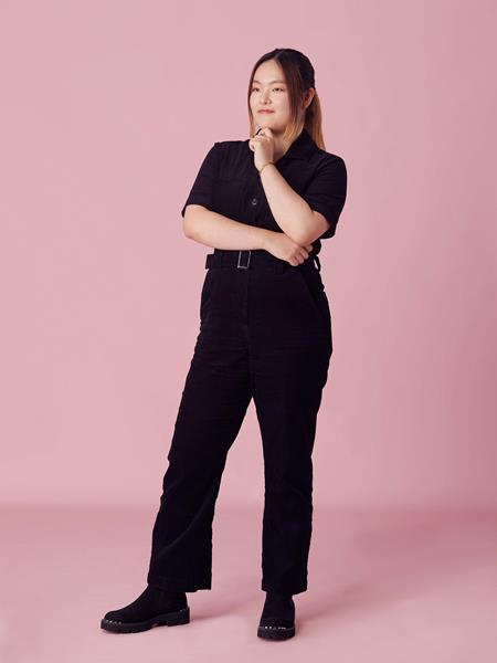 Woman standing with hand on chin in all black clothing