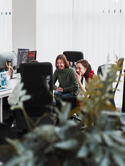 Colleagues at their desk laughing together